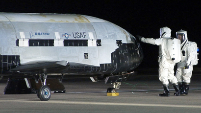 This image provided by Vandenberg Air Force Base shows technicians examining the X-37B unmanned spaceplane shortly after landing Friday Dec. 3, 2010 at Vandenberg Air Force Base, Calif. The X-37B slipped out of orbit and landed after a successful maiden flight that lasted more than seven months, the Air Force said.