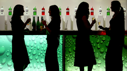 four women standing in front of a green bar.