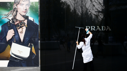 A woman cleans the brand logo at a Prada fashion boutique in Beijing, China, September 16, 2016. REUTERS/Thomas Peter