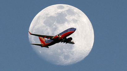 A Southwest Airlines passenger plane crosses the waxing gibbous moon in Whittier, Saturday, May 30, 2015.