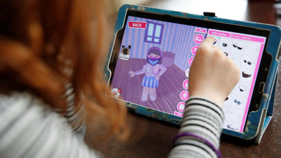 Alice Wilkinson (7) adds a face mask to her character on the game 'Roblox' at her home in Manchester.