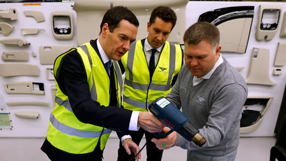 Britain's Chancellor of the Exchequer George Osborne (L) talks to a worker in the trim facility at Bentley Motors in Crewe, northern England December 4, 2014.