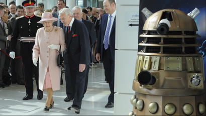 Britain's Queen Elizabeth II walks past a Dalek from the Doctor Who television series during a visit to the BBC's new buildings MediaCity in Salford, Greater Manchester, England, Friday March 23, 2012. The Queen and the Duke of Edinburgh visited Manchester and officially opened hospitals, toured the new BBC building and officially started a Sport Relief Mile fun run. (AP Photo/Andrew Yates, Pool)
