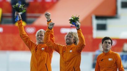 Winner Michel Mulder of the Netherlands (C), his twin brother second-placed Ronald Mulder (L), and their compatriot third-placed Jan Smeekens celebrate during the flower ceremony for the men's 500 metres speed skating race at the Adler Arena during the 2014 Sochi Winter Olympics February 10, 2014. REUTERS/Issei Kato (RUSSIA - Tags: OLYMPICS SPORT SPEED SKATING) - RTX18JJ0