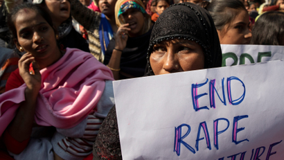 A demonstrator holds a placard as others shout slogans during a protest against the alleged rape and murder of a 27-year-old woman on the outskirts of Hyderabad, in New Delhi