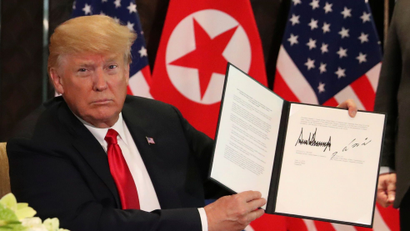 U.S. President Donald Trump shows the document, that he and North Korea's leader Kim Jong Un signed acknowledging the progress of the talks and pledge to keep momentum going, after their summit at the Capella Hotel on Sentosa island in Singapore June 12, 2018.
