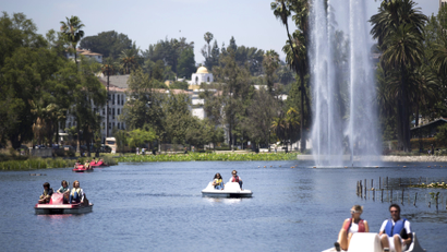 People ride paddle boats on a hot day at Echo Park Lake in Los Angeles, California