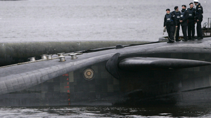 Crew from HMS Vengeance, a British Royal Navy Vanguard class Trident Ballistic Missile Submarine, stand on their vessel as they return along the Clyde river to the Faslane naval base near Glasgow, Scotland December 4, 2006. British Prime Minister Tony Blair committed to keeping a British nuclear arsenal well into the 21st century on Monday, saying the government planned to order new nuclear-armed submarines to replace its existing fleet. REUTERS/David Moir (BRITAIN) - RTR1K1MH