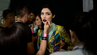 Models get finishing touches put on their makeup as they prepare to take the runway wearing creations by Mexican fashion house Pineda Covalin, at Mercedes-Benz Fashion Week in Mexico City, Tuesday, April 14, 2015. (AP Photo/Rebecca Blackwell)