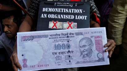 An image of a demonstrator holding a replica of an abolished 1000-rupee note during a protest, organised by India's main opposition Congress party, to mark a year since demonetisation