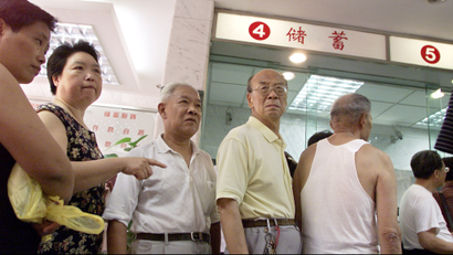 Chinese depositors queue to withdraw money at a bank in China's financial capital of Shanghai September 10, 2002. The service culture at China's state banks, legacy of a socialist-style planned economy in which their major role was to channel household savings into a creaky industrial sector. With over half of corporate loans having gone bad and customer-savvy foreign banks setting up shop, China's banks need to start rolling out service fast to wean themselves off interest income, tidy balance sheets and diversify risk, analysts said. REUTERS/Claro Cortes