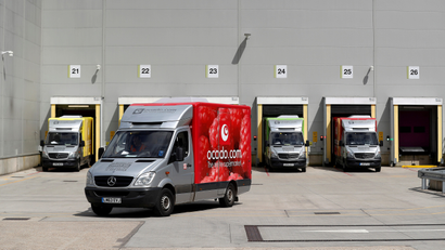 An Ocado delivery truck leaves a warehouse.