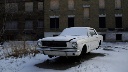 An older model Ford Mustang sits on cinder blocks with missing wheels near an abandoned apartment building in Detroit, Michigan January 7, 2015. Detroit, also known as the Motor City, is the historic hub of automobile manufacturing in the United States. A federal judge in December 2013 formally declared the city bankrupt but it won court approval to exit bankruptcy last November. Once the proud symbol of U.S. industrial strength, Detroit fell on hard times after decades of population loss, rampant debt and financial mismanagement left it struggling to provide basic services to residents. The Detroit car show, formally the North American International Auto Show, is being held for the 26th year and represents the turn in the city's fortune with 2014 being the best year for U.S. car sales since 2006. Reuters photographer Joshua Lott documented old or damaged cars, a common element in a series of cityscapes in the former automobile industry giant. REUTERS/Joshua Lott (UNITED STATES - Tags: TRANSPORT CITYSCAPE SOCIETY BUSINESS TPX IMAGES OF THE DAY) ATTENTION EDITORS: PICTURE 01 OF 16 FOR WIDER IMAGE PACKAGE 'WRECKED IN DETROIT' TO FIND ALL IMAGES SEARCH 'CITYSCAPES LOTT' - LM2EB1D0JVA01
