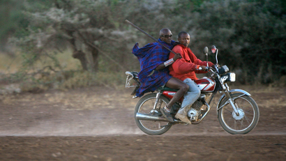 Masai men ride on a motorcycle in the Amboseli national park, Kenya, March 21 2007.