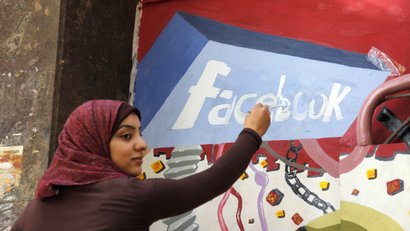 FILE - In this March 30, 2011, file photo. an art student from the University of Helwan paints the Facebook logo on a mural commemorating the revolution that overthrew Hosni Mubarak in the Zamalek neighborhood of Cairo, Egypt. In a statement to The Associated Press on Wednesday, Dec 30, 2015, Facebook said it is disappointed that a program providing free basic Internet services to over three million Egyptians has been shut down. It said the service provided Internet access to more than a million people who were not previously connected.