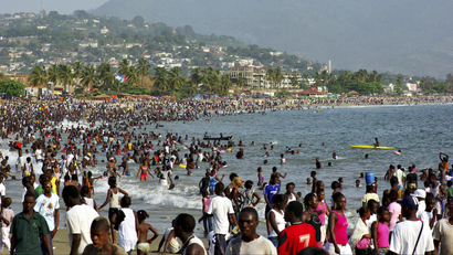 A beach in Freetown, the capital city of Sierra Leone, with a ton of people in and out of the water