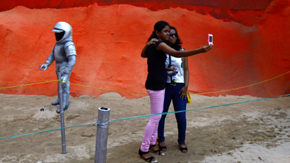 Visitors take a selfie at a pandal, a temporary platform, with art installation titled "Mars Mission" as part of the Durga Puja festival in Kolkata