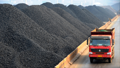 -A truck passes by piles of coal at a coalyard at the Port of Lianyungang in Lianyungang city, east Chinas Jiangsu province, 9 April 2011. China is expected to consume approximately 4 billion metric tons of coal in 2015, 700 million metric tons more than that of 2010, said Chen Qi, director of the regulating division at the China National Coal Association (CNCA). Chen added that about 300 million metric tons of coal reserves will be added this year.(Imaginechina via AP Images