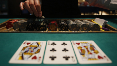 A dealer picks up chips on a mock black jack casino table