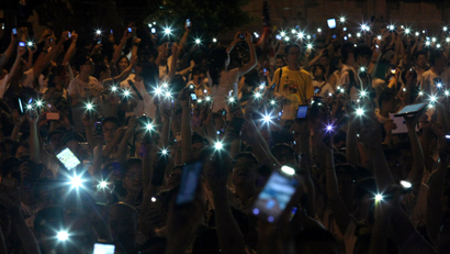 People wave cell phones as they take part in a demonstration in front of the Presidential Office in Taipei August 3, 2013. Hundreds of thousands of demonstrators gathered on Saturday to mourn for soldier Hung Chung-chiu, who died of organ failure after suffering a heatstroke caused from performing punishment exercises on July 4, and to demand further investigation into Hung's case, according to event organizers.