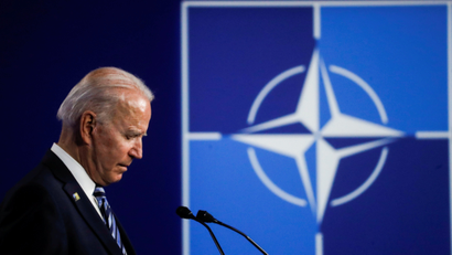 Joe Biden speaks by a NATO sign