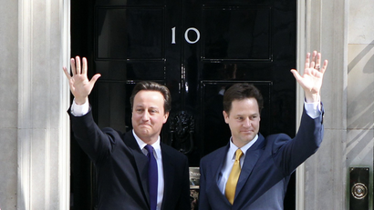 Britain's Prime Minister David Cameron (L) and Deputy Prime Minister Nick Clegg wave on the steps of 10 Downing Street.