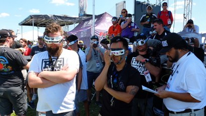 Pilots at the drone nationals watch a race through video goggles.