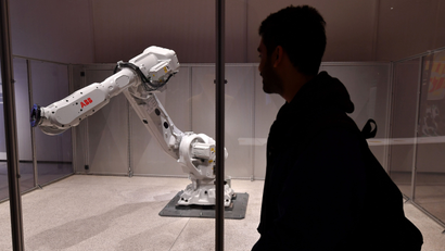 A man looks at an exhibit entitled 'Mimus' a giant industrial robot which has been reprogrammed to interact with humans during a photocall at the new Design Museum in Kensington, London on November 17, 2016.