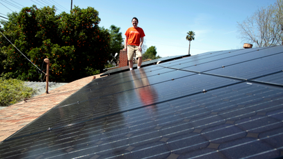 Mike Jones stands next to solar panels on the roof of his home in Los Angeles, California March 18, 2011. Jones leased 22 solar panels from solar electric system company Sungevity. The panels would have cost him $13,000, but the 20-year lease cost $4,000. The first month after the panels were installed Jones' electricity bill went down from $160 to $11. (UNITED STATES - Tags: ENVIRONMENT ENERGY)