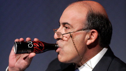 Coca-Cola CEO Muhtar Kent takes a drink of a Coca-Cola Zero while addressing investors at a conference in which a vision for the future of the company is announced, Monday Nov. 16, 2009, in Atlanta.