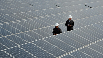 Chinese inspectors check arrays of solar panels at a photovoltaic power plant in Xiji town, Zaozhuang city, east Chinas Shandong province.