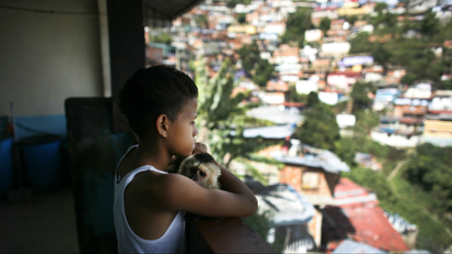 A boy looks out over the slums of Caracas
