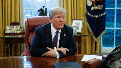 US president Donald Trump sits at his desk in the Oval Office.
