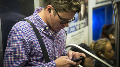 guy reading on smartphone in subway