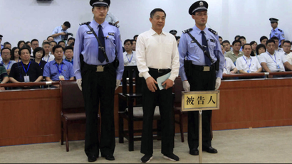In this photo released by the Jinan Intermediate People's Court, Bo Xilai, center, who was tried last month on charges of taking bribes, embezzlement and abuse of power, stands inside the court in Jinan, in eastern China's Shandong province, Sunday, Sept. 22, 2013. The Chinese court convicted the fallen politician of corruption and sentenced him to life in prison. (AP Photo/Jinan Intermediate People's Court