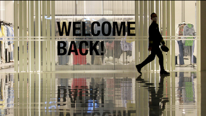 Worker walks past a "welcome back!" sign during preparations ahead of reopening of a shopping mall, in Jakarta.