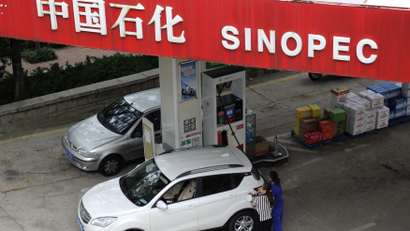 A customer gets the tank of her car filled at a Sinopec gas station in Qingdao, Shandong province