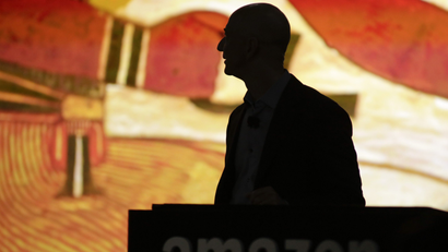 Amazon CEO Bezos is silhouetted during a presentation of his company's new Fire smartphone in Seattle