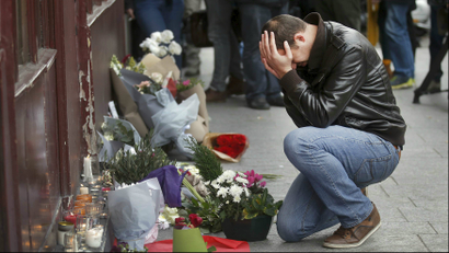 A man pays his respect outside the Le Carillon restaurant the morning after a series of deadly attacks in Paris.