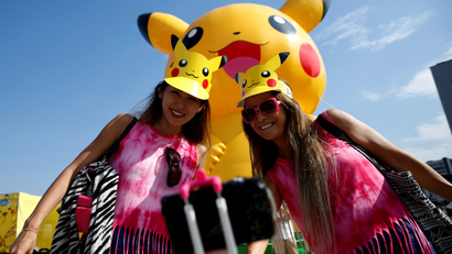 Women take a selfie in front of a large Pikachu figure at a Pokemon Go Park event in Yokohama, Japan August 9, 2017