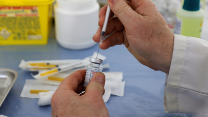 A person extracts a Covid-19 vaccine from a vial