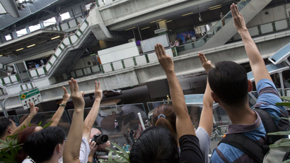 Protesters raise three fingers, representing liberty, brotherhood and equality, during an anti-coup demonstration in Bangkok, Thailand Sunday, June 1, 2014. Hundreds of demonstrators shouting "Freedom!" and "Democracy!" gathered Sunday near a major shopping mall in downtown Bangkok to denounce the country's May 22 coup despite a lockdown by soldiers of some of the city's major intersections. (AP Photo/Sakchai Lalit)