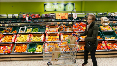 A customer shops at a Tesco shop in Bishop's Stortford, southern England November 26, 2012. Eight months ago Tesco Plc chief executive Phil Clarke set out a 1 billion pound ($1.6 billion) recovery plan to arrest the group's worrying loss of market share. How well it's working may start to emerge next week. Picture taken November 26, 2012. REUTERS/Suzanne Plunkett (BRITAIN - Tags: BUSINESS FOOD) - RTR3B22H