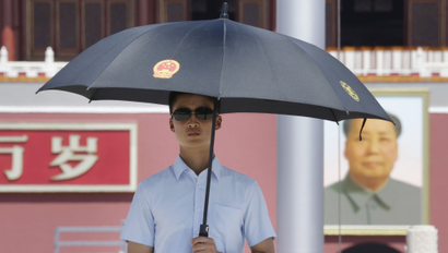 A paramilitary police officer in plain-clothes holding an umbrella keeps watch on Beijing's Tiananmen Square, August 27, 2015. Major Western leaders will not attend a military parade in China next week to mark the end of World War Two, leaving President Xi Jinping to stand with leaders and officials from Russia, Sudan, Venezuela and North Korea at his highest-profile event of 2015.