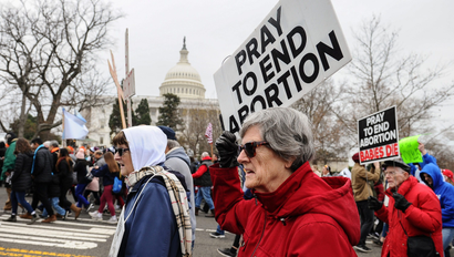 Anti-abortion activists march with signs past the US Capitol
