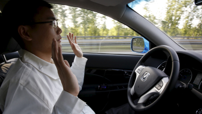 Li Zengwen, a development engineer at Changan Automobile, lifts his hands off the steering wheel as the car is on self-driving mode during a test drive on a highway in Beijing, China, April 16, 2016.