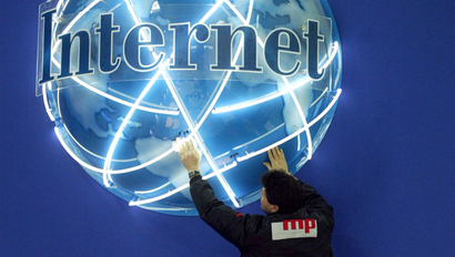 A WORKER ADJUSTS AN ADVERTISING GLOBE IN PREPARATION FOR WORLD'S LARGEST COMPUTER FAIR CEBIT IN HANOVER.