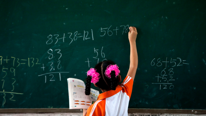 girl at blackboard doing math
