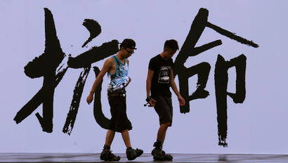 Pro-democracy activists walk past a backdrop with Chinese characters that read "disobedience", built for an Occupy Central civil disobedience campaign, near the financial Central district in Hong Kong August 31, 2014. Hong Kong is poised for a showdown with China when the Chinese parliament met on Sunday, with the largely rubber-stamp body likely to snuff out hopes for a democratic breakthrough in the regional financial hub at elections due in 2017. REUTERS/Bobby Yip (CHINA - Tags: POLITICS) - RTR44DP1