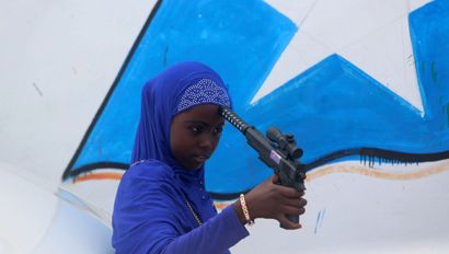 A Somali girl plays with a toy gun after attending Eid al-Fitr prayers to mark the end of the fasting month of Ramadan in Somalia's capital Mogadishu, July 6, 2016.